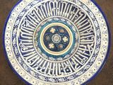 assiette en céramique bleue et blanche ornée d'une calligraphie arabe