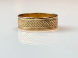 a picture of a gold wedding ring on a white surface