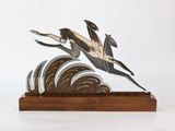 une sculpture représentant un oiseau survolant un tas de pièces de monnaie