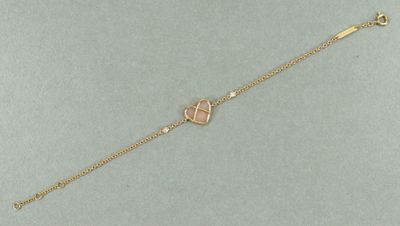 un bracelet à chaîne en or avec une breloque en forme de cœur