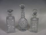 three clear glass bottles sitting next to each other on a white surface