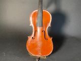 an old violin sitting on top of a table next to a gray wall