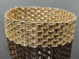 a close up of a gold bracelet on a black surface