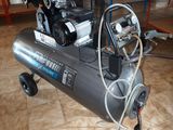 a small air compressor sitting on a cart in a room