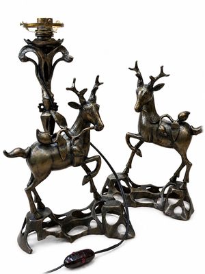 deux statues en bronze représentant un cerf et un homme sur un traîneau