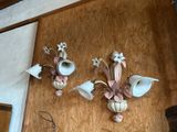 two wall sconces that have flowers on them