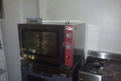 un micro-ondes posé sur une cuisinière dans une cuisine