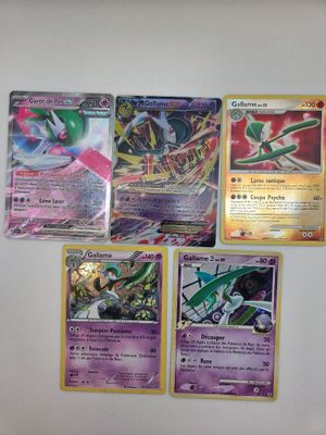 Plusieurs cartes Pokémon sont accrochées au mur d'une pièce.