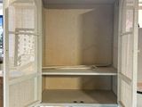 an open cabinet in the middle of a room with a blue floor
