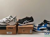three pairs of shoes are sitting on top of boxes on a table