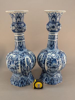 une paire de vases bleus et blancs posés l'un à côté de l'autre sur une table