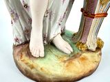 a figurine of a woman holding a vase on top of a table