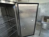 an open refrigerator in the middle of a room with a table