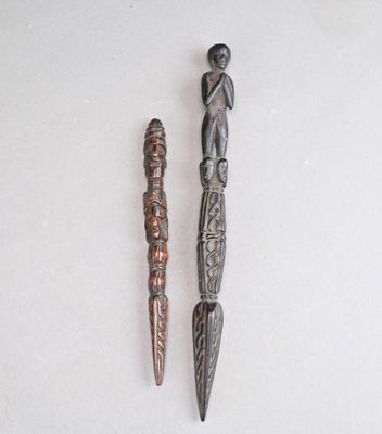 Deux objets métalliques sont posés l'un à côté de l'autre sur une surface blanche.