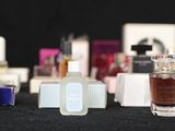 several bottles of perfume are lined up on a black surface