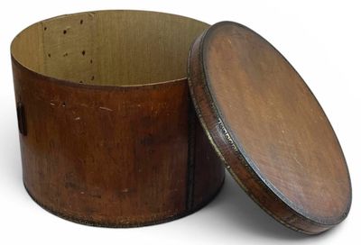 une vieille boîte en bois avec un couvercle, posée sur une surface blanche