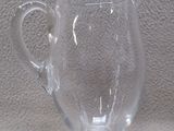 un pichet en verre transparent posé sur une table