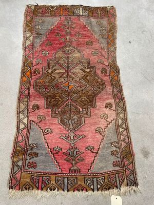 an old rug with a pink and brown design on it