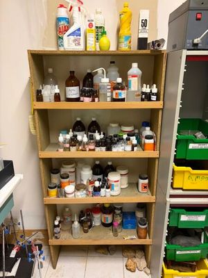 une étagère remplie de bouteilles et de récipients dans une pièce