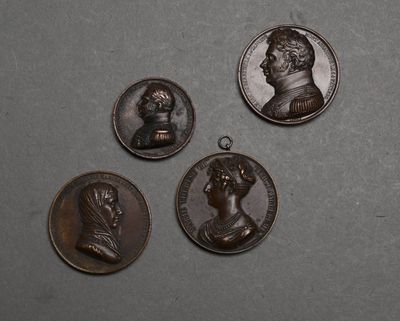quatre médaillons en bronze représentant des hommes et des femmes sur un fond gris
