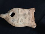 a small clay object with a hole in it