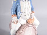 une figurine représentant un homme assis sur un tonneau