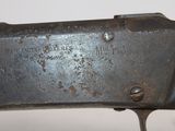 an old gun with a metal handle on a white surface