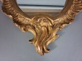 a mirror with a gold frame on the wall