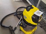 un aspirateur jaune posé par terre dans une pièce