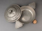 a silver bowl with a lid and a wooden spoon next to it