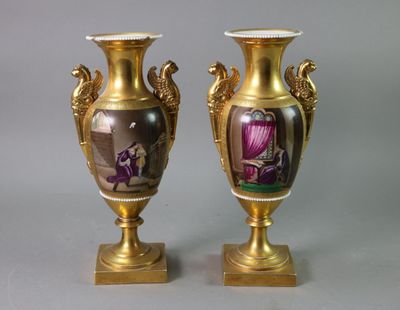 pair of gold vases with a picture of a woman and a man on them