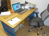 un bureau avec un ordinateur portable et une chaise à côté
