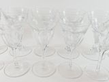 several empty wine glasses are lined up on a white surface