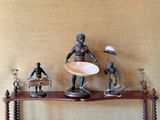 Plusieurs figurines sont posées sur une étagère sur laquelle se trouve un bol.
