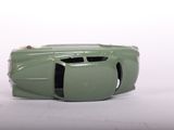 a green toy car that is sitting on a white surface