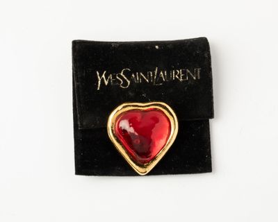 an image of a red heart shaped broochle on a black velvet pouch