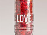 un comprimé contenant des paillettes rouges, posé sur une surface blanche