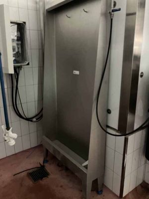 une grande porte en acier inoxydable dans une salle de bains équipée d'une douche