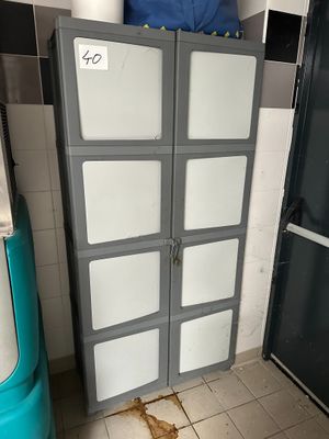 a refrigerator and a trash can in a dirty kitchen