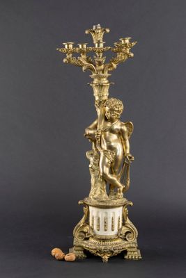 a gold plated candelab with a statue of a man holding a candelab