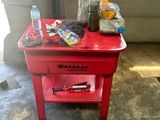 a small red table with a bottle of water on it