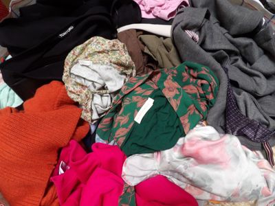 une pile de vêtements posée sur un lit