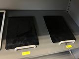 three ipads sitting on a shelf next to each other