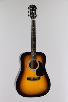 an acoustic guitar hanging on a wall in a room