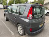 a small grey van parked in a parking lot