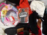 a pile of clothes and shoes that are on a bed