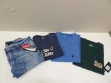 a pile of t - shirts and jeans on a table