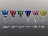 six different colored wine glasses are lined up in a row