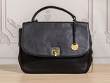 a black handbag sitting on top of a wooden table