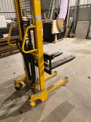un chariot élévateur jaune garé dans un entrepôt